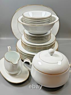 Set of classic Noritake P589 dinner ware for six white with gold rim and gold